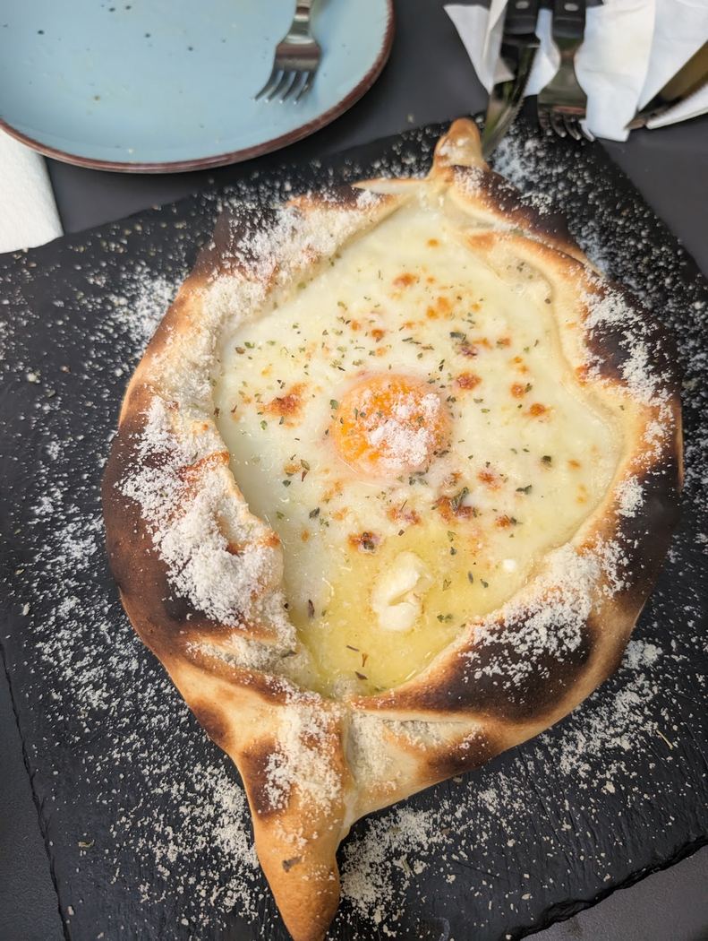 Barco de queso fundido con huevo y bacon, servido en una base crujiente